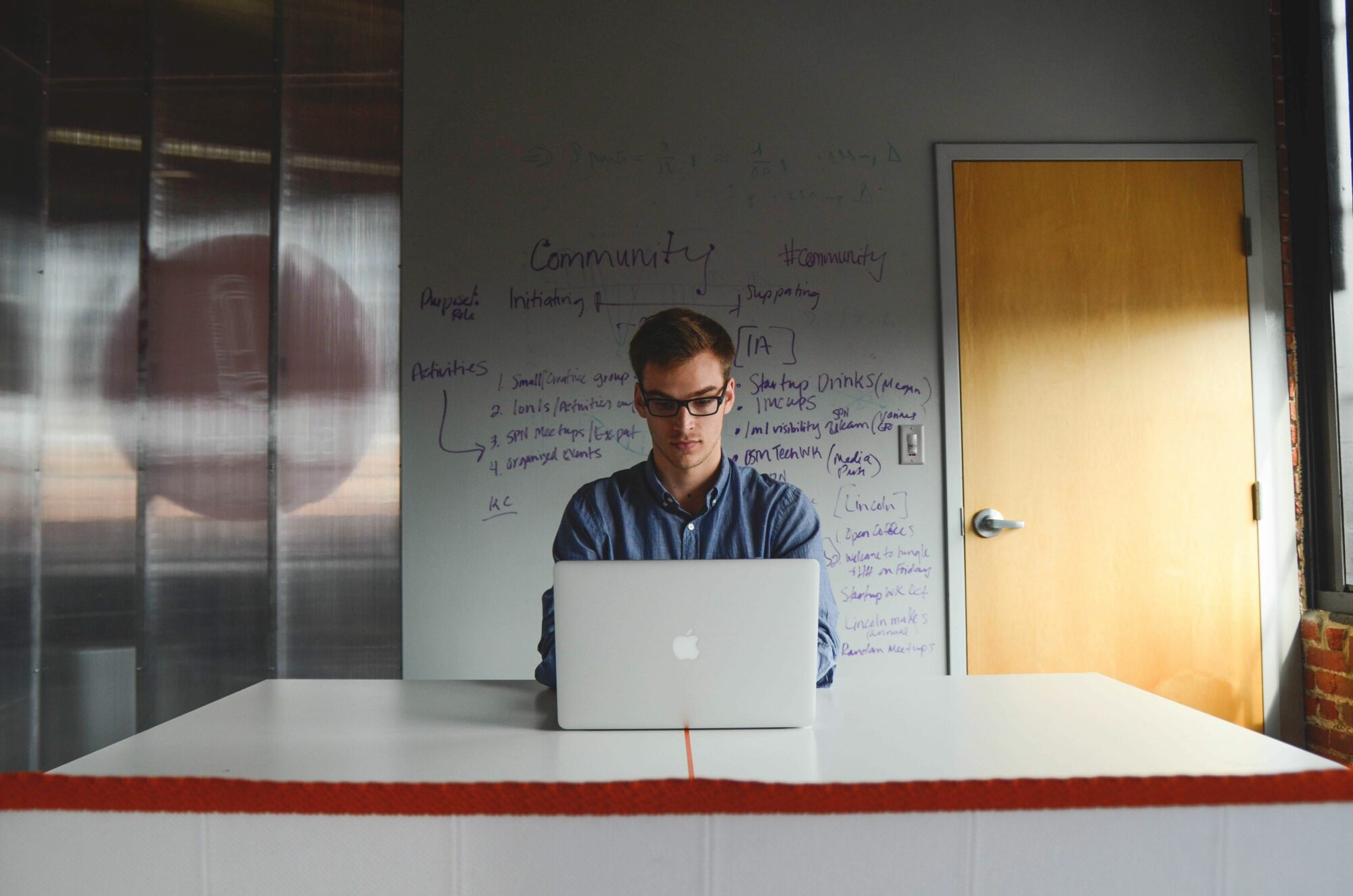 Man On Laptop In Front of Whiteboard Free Stock Picture