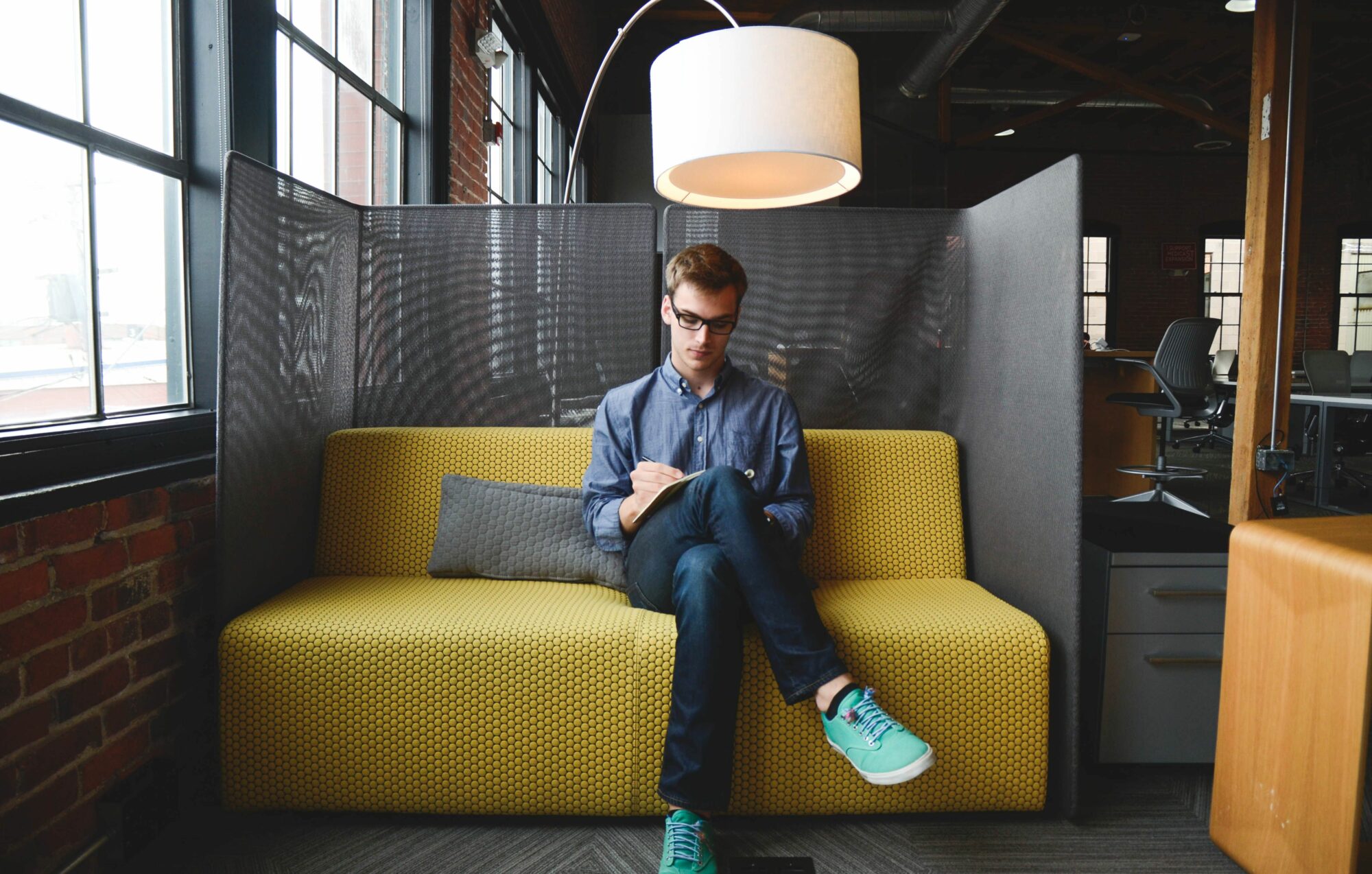 Man Sitting On Yellow Couch Writing Free Stock Picture