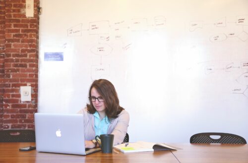 Woman Working On Laptop In Front of Whiteboard Free Stock Picture